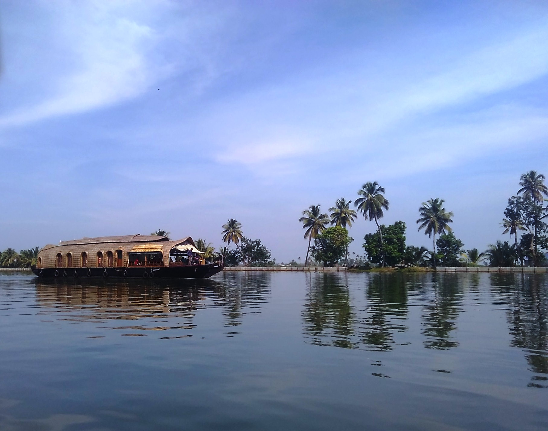 Houseboat cruising the palm-lined backwaters of Alleppey, Kerala